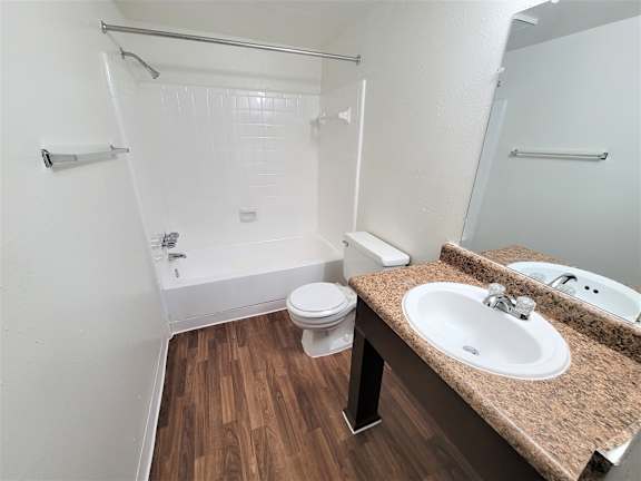 A bathroom with a toilet, sink, and shower.