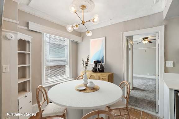 A dining room with a white table and chairs.