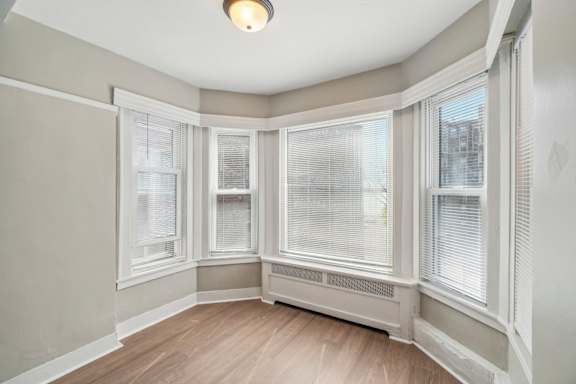 A sunny room with a window and a wooden floor.