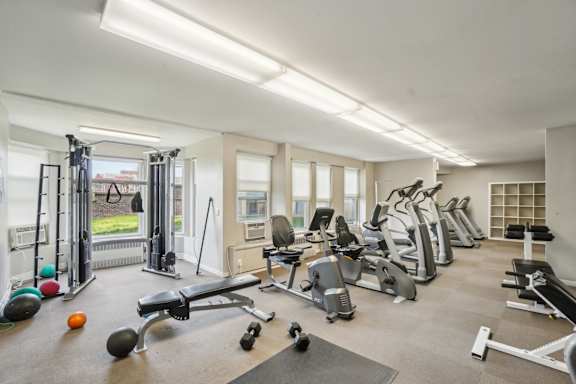 A spacious gym with a variety of equipment including treadmills, weights, and exercise balls.