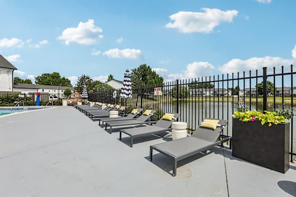 A row of sun loungers are arranged on a patio.