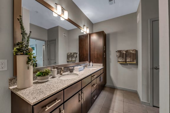 a bathroom with granite counter tops and a large mirror