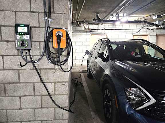 a car is plugged into a car charger in a parking garage