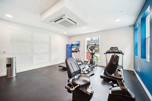 A gym with treadmills, exercise bikes, and other equipment.