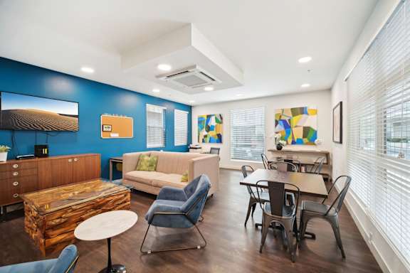 A living room with a blue wall and a wooden coffee table.