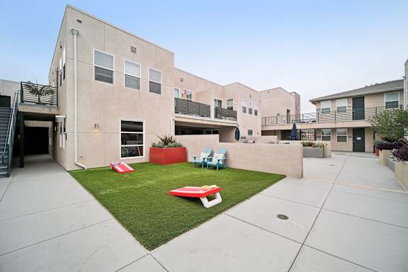 A courtyard with a lawn and a red bench.