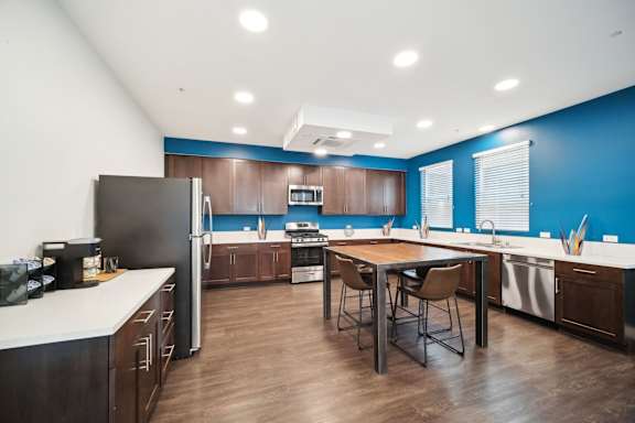 A kitchen with a table and chairs in the middle of it.