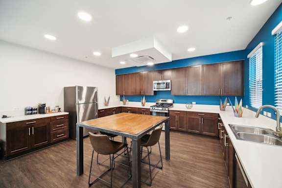 A kitchen with a table and chairs in the middle of it.
