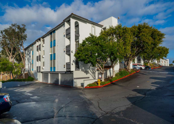 a large white building with blue windows and a parking lot
