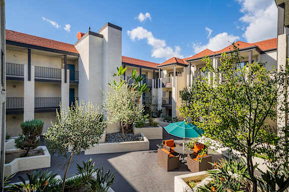 a courtyard with tables and umbrellas at the resort