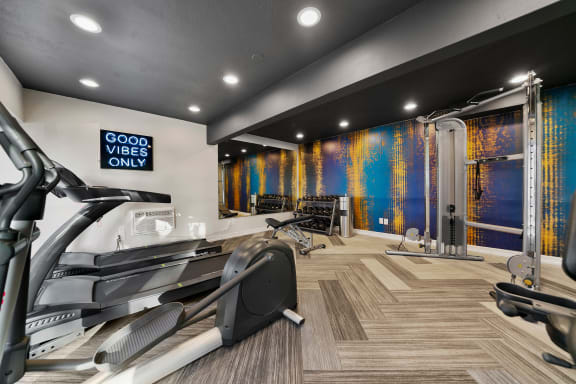 a gym with treadmills and other exercise equipment on the floor and a wall