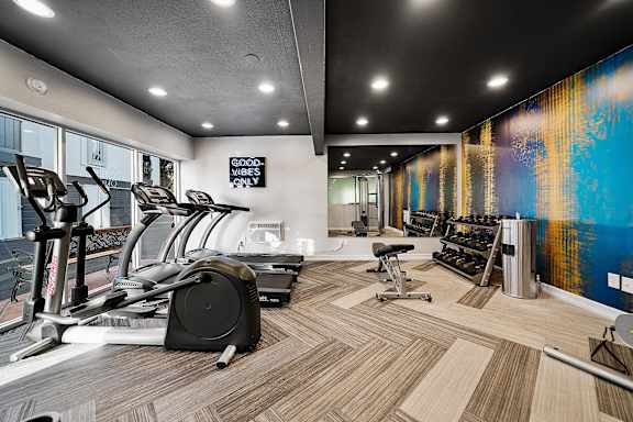 A gym with treadmills, elliptical machines, and other exercise equipment.