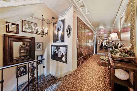 a long hallway with pictures on the wall and a staircase