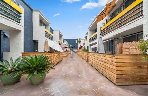 a communal area in a building with a wooden fence and potted plants