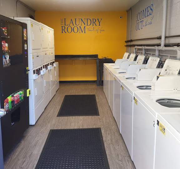 a laundry room with rows of washes and dryers