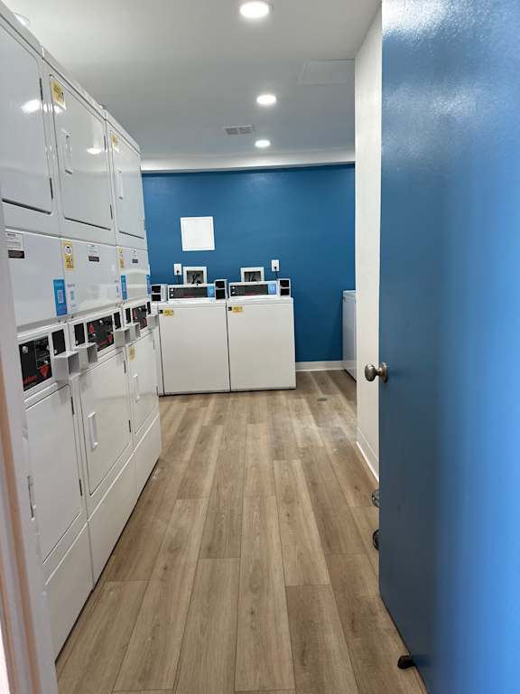A kitchen with white cabinets and a blue wall.
