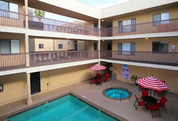 A pool in a courtyard surrounded by apartment buildings.