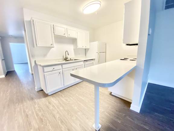 A white kitchen with a table and chairs.