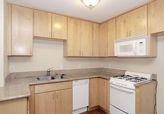a kitchen with white appliances and wooden cabinets