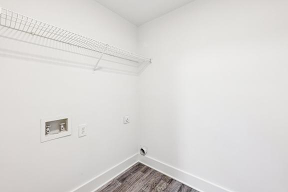 A white wall with a socket and a shelf.