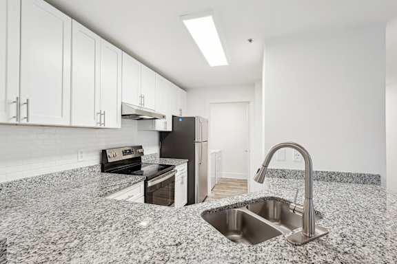 A kitchen with granite countertops and stainless steel appliances.