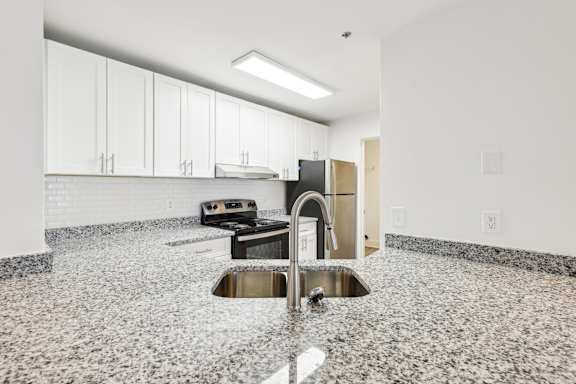 A kitchen with granite countertops and stainless steel appliances.