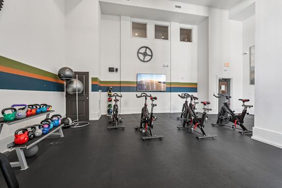 A gym with exercise bikes and kettlebells.