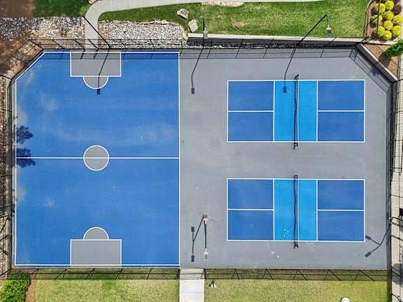 A tennis court with blue surface and white lines.