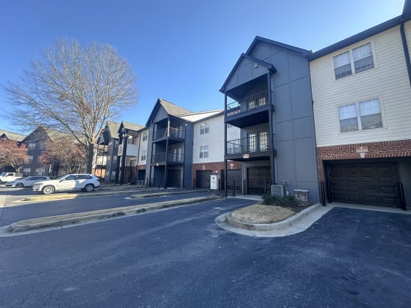 a street view of an apartment building with cars parked in front