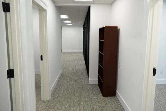 A long hallway with a brown filing cabinet on the right.