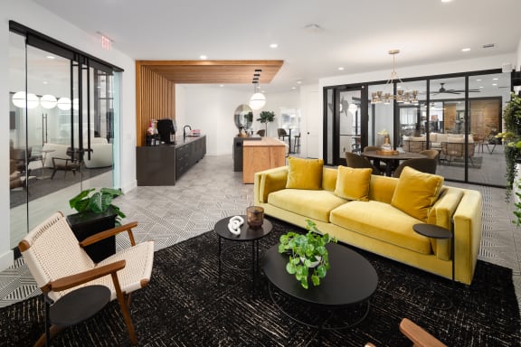 a living room with a yellow couch and a black rug