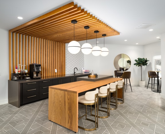 a kitchen with a wooden counter and a bar with chairs