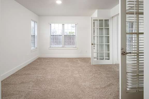 A room with a carpeted floor and a door with a window.