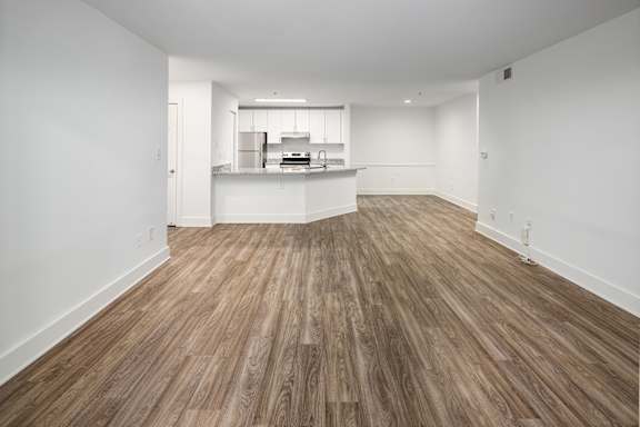 A room with wooden flooring and white walls.