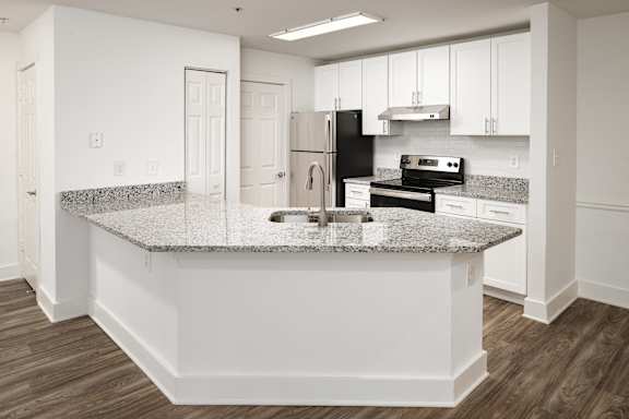 a kitchen with stainless steel appliances, white cabinets and a granite counter top