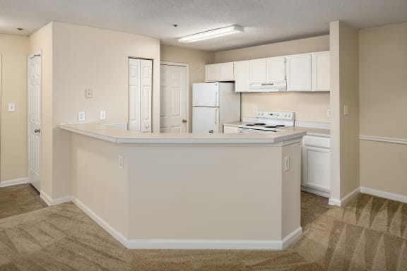 an empty kitchen with white cabinets and a counter top