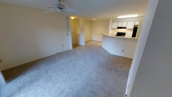 A room with a ceiling fan and carpeted floor.