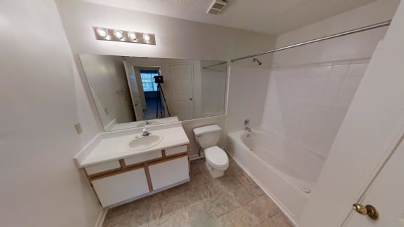 A bathroom with a sink, toilet, and bathtub.