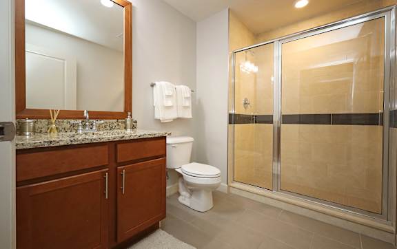 A bathroom with a toilet, sink, and shower.