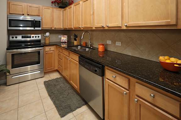 Maple-Finished Custom Cabinets Granite Countertops and Porcelain Tile in the Bathrooms and Kitchen at The Residences at 668 Apartments, Ohio