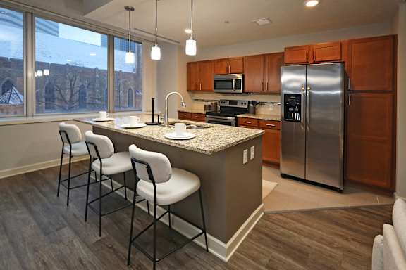 A kitchen with a refrigerator, microwave, and oven.