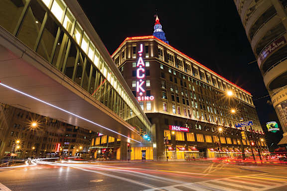 A long exposure shot of a city street at night with the Jack London building illuminated.