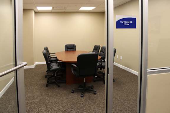 A conference room with a table and chairs.