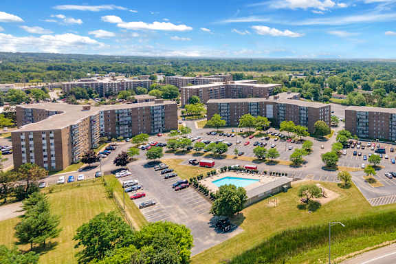 A large apartment complex with a parking lot in front.