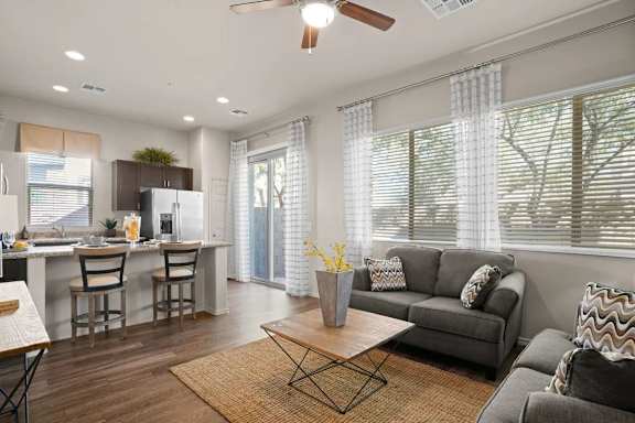 A modern living room with a grey couch and a wooden coffee table.