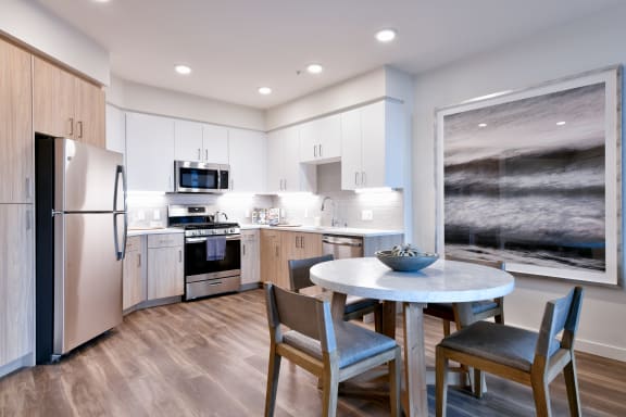 a kitchen with stainless steel appliances and a round table with chairs