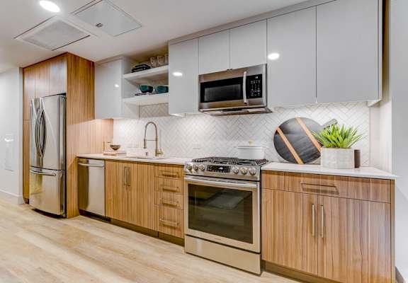 A modern kitchen with wooden cabinets and stainless steel appliances.