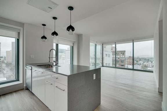 A modern kitchen with a large island and pendant lights.