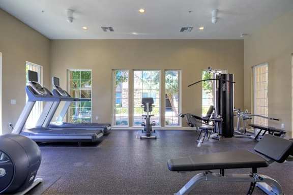 A spacious gym with treadmills, weights, and exercise equipment.