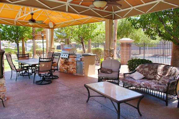A patio with a table and chairs under a canopy at Avalon at Seven Hills Apartments, Nevada
